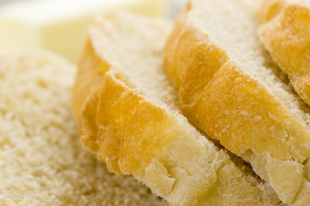 Pan de masa fermentada recién horneado en rodajas sobre tabla de cortar.