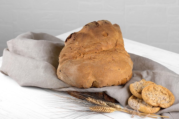 El pan de Matera Pane di Matera en servilleta de lino sobre fondo de madera blanca pan de masa fermentada típico del sur de Italia