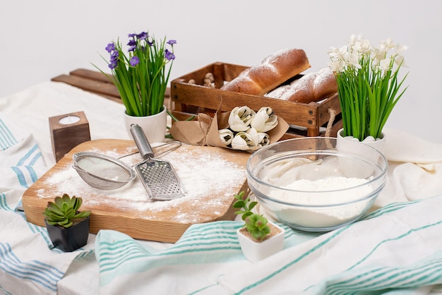 Pan en la mesa decoración de flores y telas cubiertos de harina en la cocinaxA