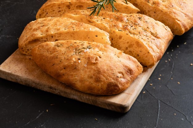 Pan de molde Ciabatta y romero sobre tabla de madera