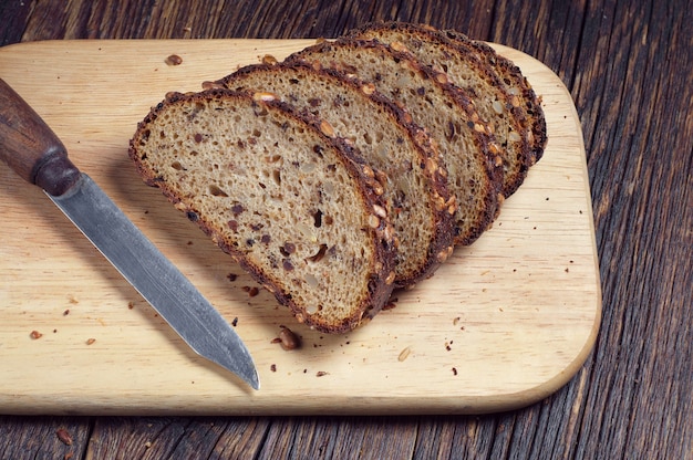 Pan de molde y el cuchillo sobre una tabla de cortar