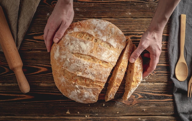 Pan natural casero con una corteza dorada en una servilleta sobre un fondo de madera antiguo Hornear productos de panadería Estilo rústico