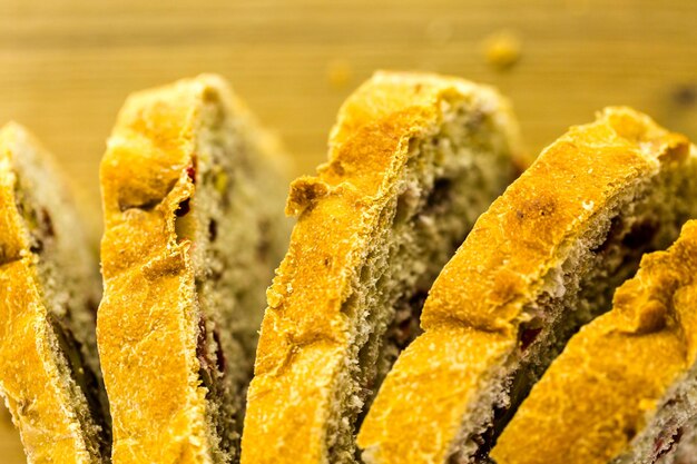 Pan de nuez de arándano de masa fermentada recién horneado en rodajas sobre la mesa.