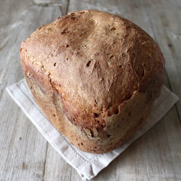 Pan de pan orgánico de masa madre de trigo de centeno integral en una servilleta de lino sobre mesa de madera natural. Concepto de pan casero Vista superior Cerrar enfoque selectivo Espacio de copia