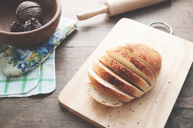 Pan de pan sobre fondo de madera con herramientas de panadería, concepto de alimentos