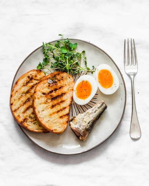 Pan a la parrilla sardinas huevos cocidos micro greens