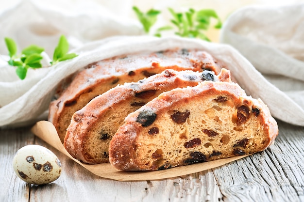 Pan de Pascua, primer plano sobre pan fruty tradicional en madera rústica con hojas frescas y huevo de codorniz