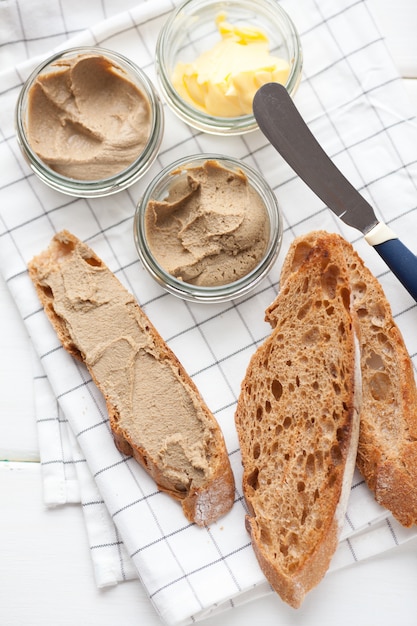 Pan con paté y mantequilla sobre un fondo textil.