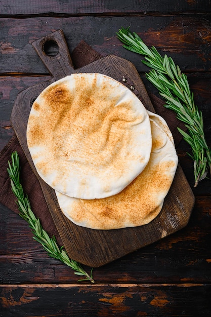 Pan de pita en la cocina en la vieja vista superior del fondo de la mesa de madera oscura endecha plana