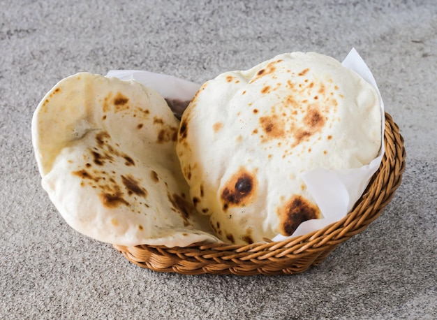 Pan de pita o Tandoori roti servido en una cesta aislada en la vista superior de fondo de Oriente Medio y la comida india