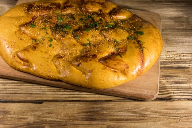 Pan pita en tabla de cortar sobre mesa de madera