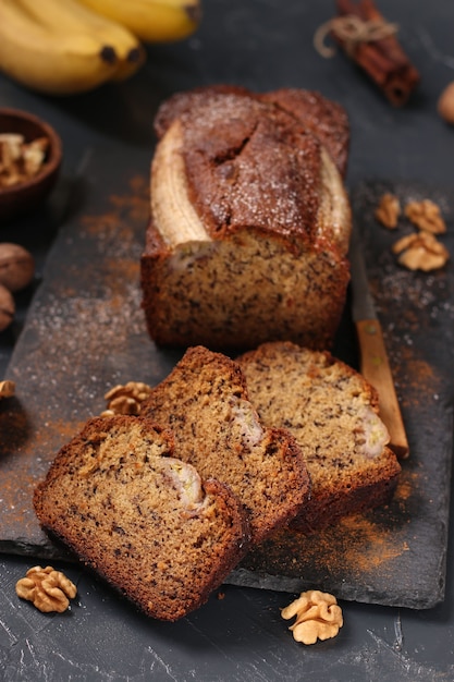 Pan de plátano casero con nueces y canela sobre un fondo oscuro