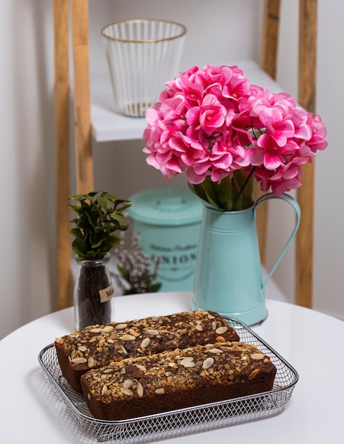 Pan de plátano en la mesa con tarro de flores