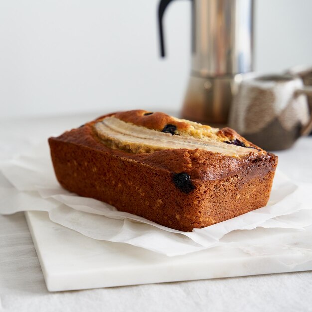 Pan de plátano, pastel entero con plátano y arándanos, desayuno matutino con café.