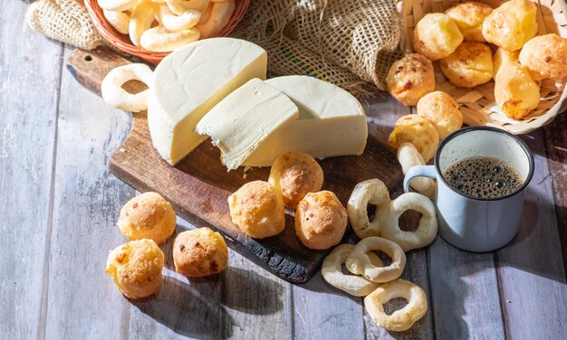 Pan de queso y más pan de queso galletas de harina de mandioca y queso de Minas dispuestos sobre una superficie rústica de madera con accesorios enfoque selectivo