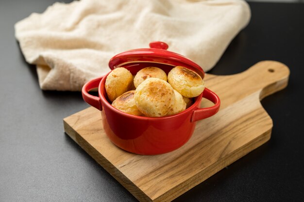 Pan de queso tradicional brasileño en una olla rústica roja