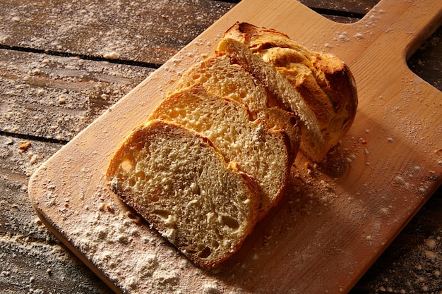 Pan rebanado de pan en tablero de madera en madera rústica