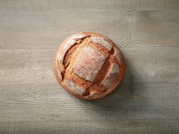 Pan recién horneado en la mesa de la cocina de madera, vista superior