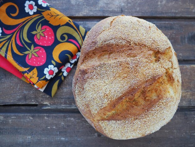 Foto pan redondo vista superior delicioso pan de maíz fresco con chispas sobre una vieja mesa de madera y una hermosa