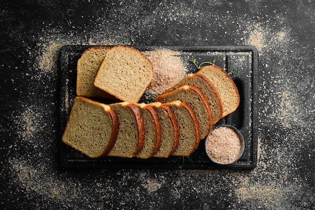 Foto pan de salvado fresco hornear vista superior fondo de piedra negra estilo rústico