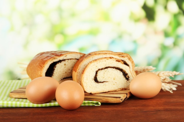 Pan con semilla de amapola en la tabla de cortar sobre fondo brillante