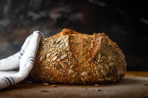 Pan de semillas sobre una pala de madera y un fondo negro de marmol