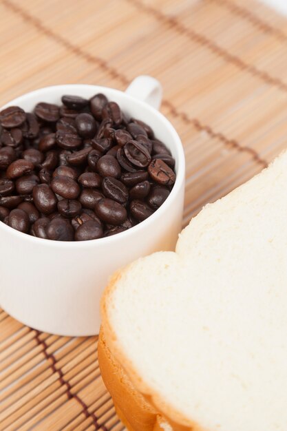 Pan y taza con granos de café.