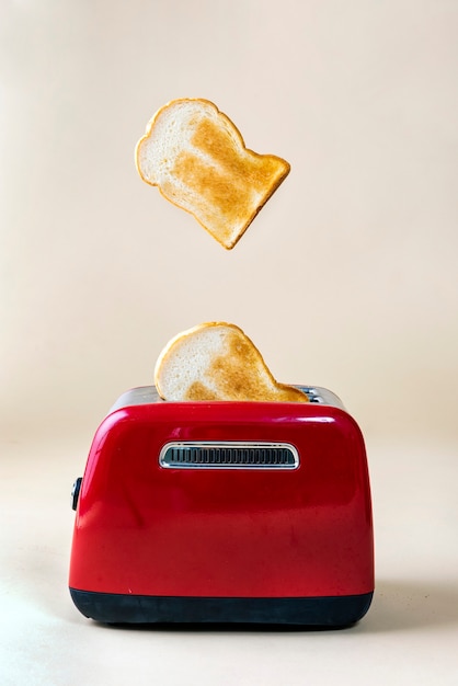 Foto pan tostado asado saliendo de una tostadora roja