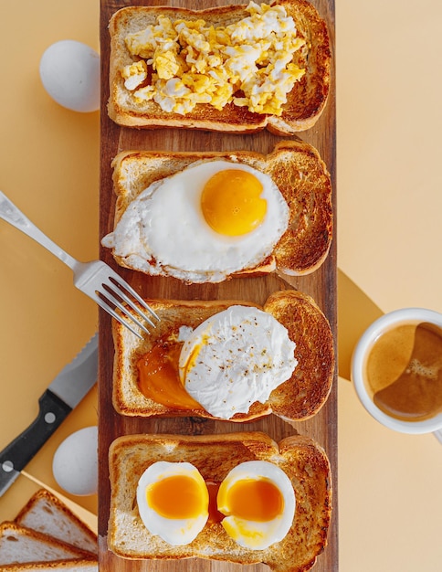 Pan tostado frito con cuatro tipos diferentes de huevos de gallina cocidos huevos revueltos huevos fritos huevo escalfado y huevo a la crema Desayuno de huevos de gallina
