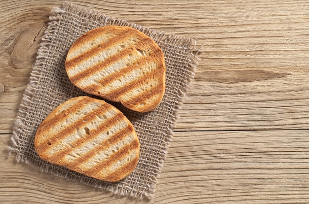 Foto pan tostado a la parrilla sobre una mesa de madera