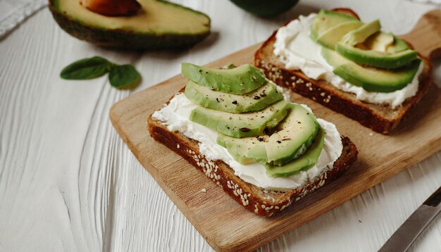 Pan tostado con queso con crema y aguacate en la mesa sándwich delicioso bocadillo sabroso