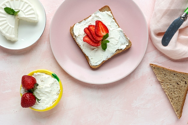 Pan tostado con queso fresco y fresas.