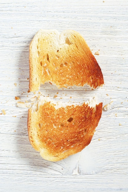Foto pan tostado rasgado en la mesa, vista superior