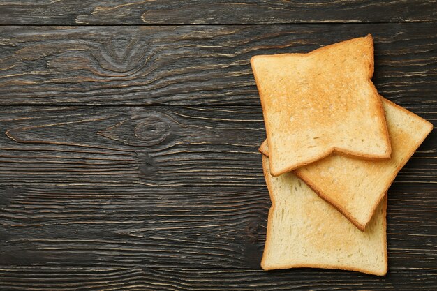 Pan tostado sabroso sobre fondo de madera