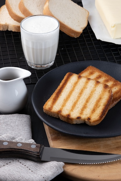 Pan tostado con una taza de leche y café, enfoque selectivo.