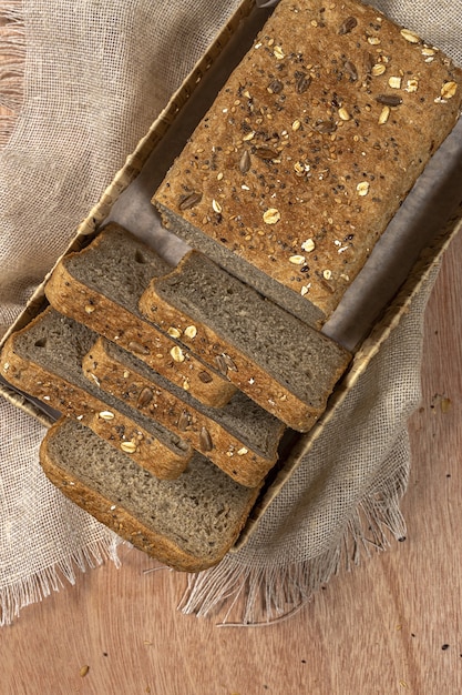 Pan tostado de trigo en rodajas con cereales aislado sobre fondo de colores.