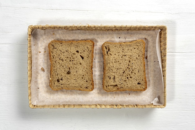 Pan tostado de trigo en rodajas con cereales aislado sobre fondo de colores.