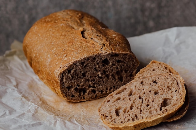 Pan tradicional pan de masa fermentada cortado en rodajas sobre un fondo de madera rústica Concepto de tradición