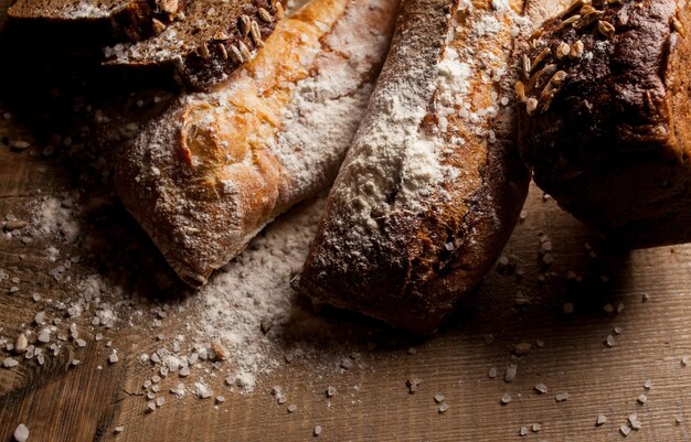 Pan tradicional recién horneado con harina sobre mesa de madera baguette fresca con harina