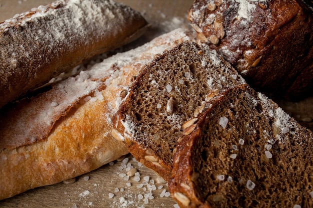 Pan tradicional recién horneado con harina sobre mesa de madera baguette fresca con harina