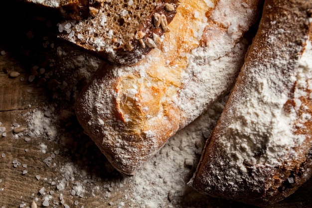 Pan tradicional recién horneado con harina sobre mesa de madera baguette fresca con harina