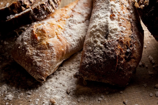 Pan tradicional recién horneado con harina sobre mesa de madera baguette fresca con harina