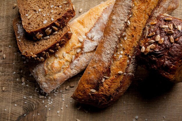 Pan tradicional recién horneado con semillas de girasol en la mesa de madera baguette fresca con sal