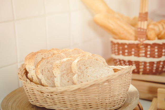 Pan de trigo integral o de grano entero en rodajas en canasta de madera