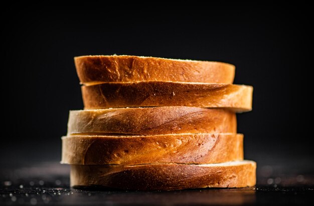 Pan de trigo en rodajas sobre un fondo negro