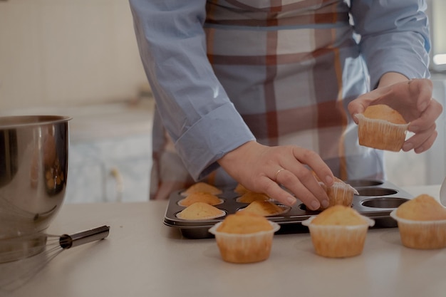 Una panadera sostiene pasteles recién horneados mostrando su pastel casero