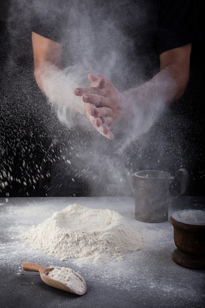 Panadero aplaudiendo las manos de harina.