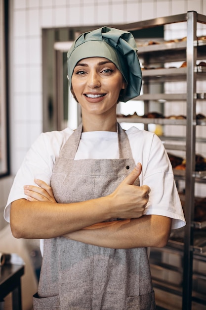 Panadero femenino en la cocina con croissants