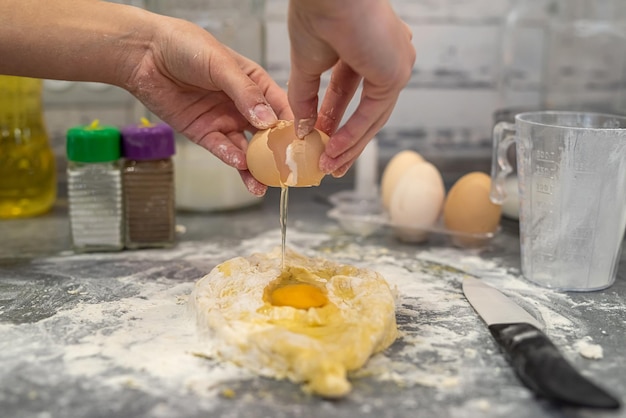 Panadero femenino profesional que prepara masa con aceite de huevos y leche para galletas de Navidad