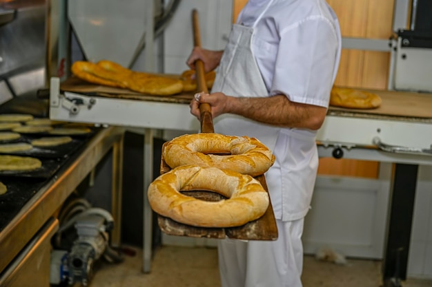 Panadero horneando pan fresco en la panadería